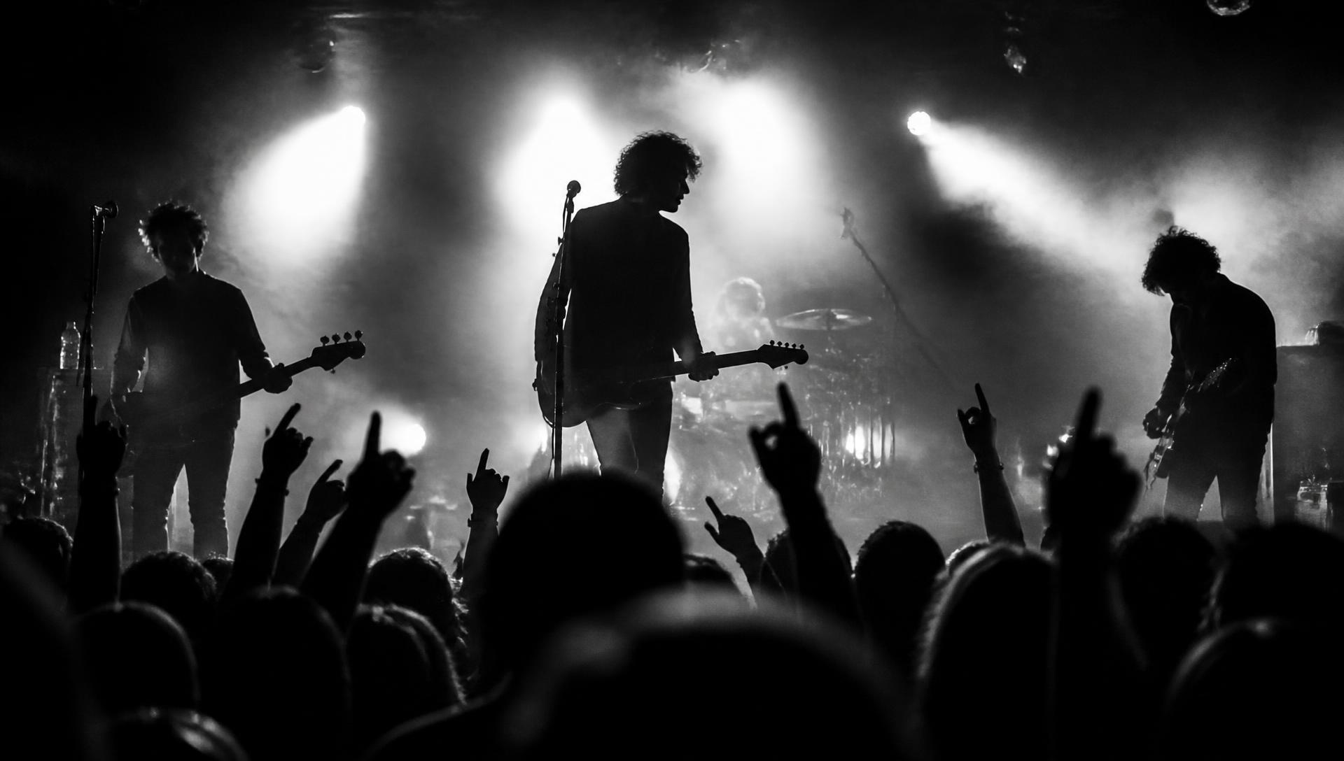 Kandara performing live on a smoke-filled stage in front of a raised-hands crowd